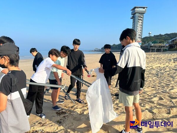 충북해양교육원을 찾은 학생들이 해수욕장에서 쓰레기를 줍고 있다.